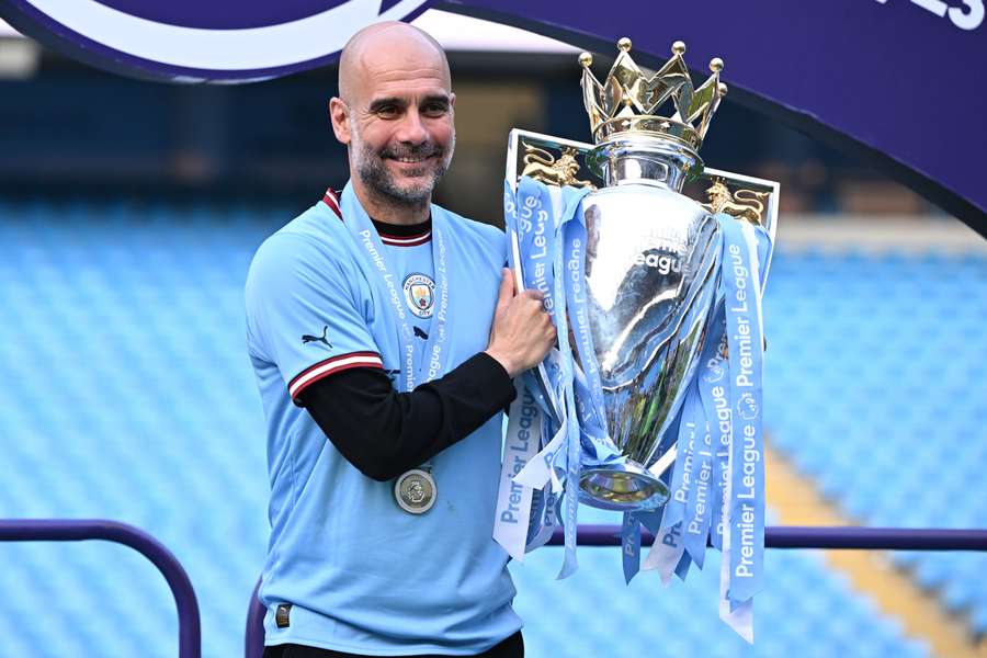 Pep Guardiola of Manchester City poses with the Premier League trophy last season