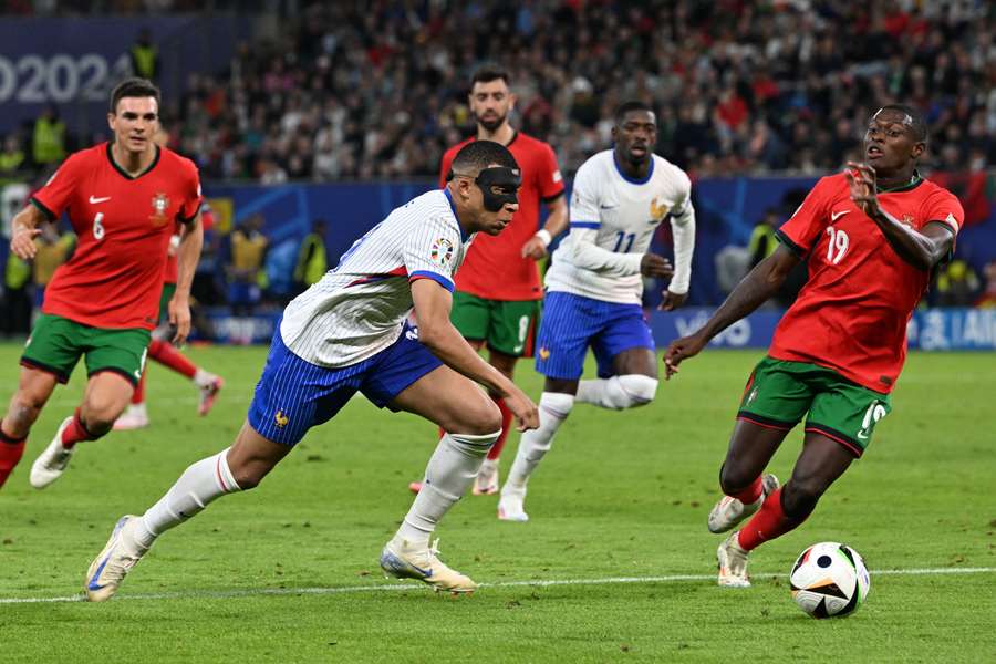 France's Kylian Mbappe in action with Portugal's Nuno Mendes