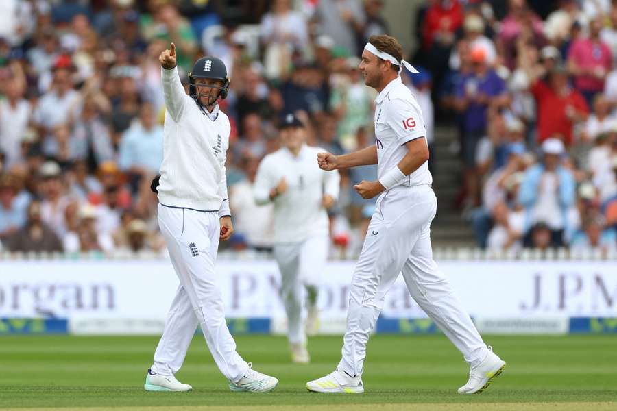 Joe Root celebrates his catch off Travis Head with Stuart Broad