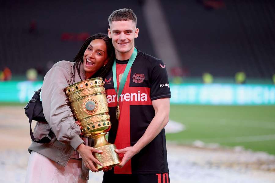 Florian Wirtz und seine Freundin posieren nach dem Gewinn des DFB Pokals mit der Trophäe.