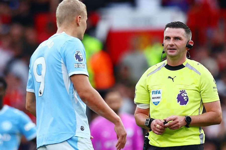 Erling Haaland and referee Michael Oliver