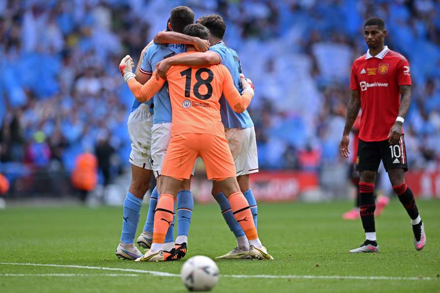 O Man City comemora no final do jogo enquanto Marcus Rashford observa