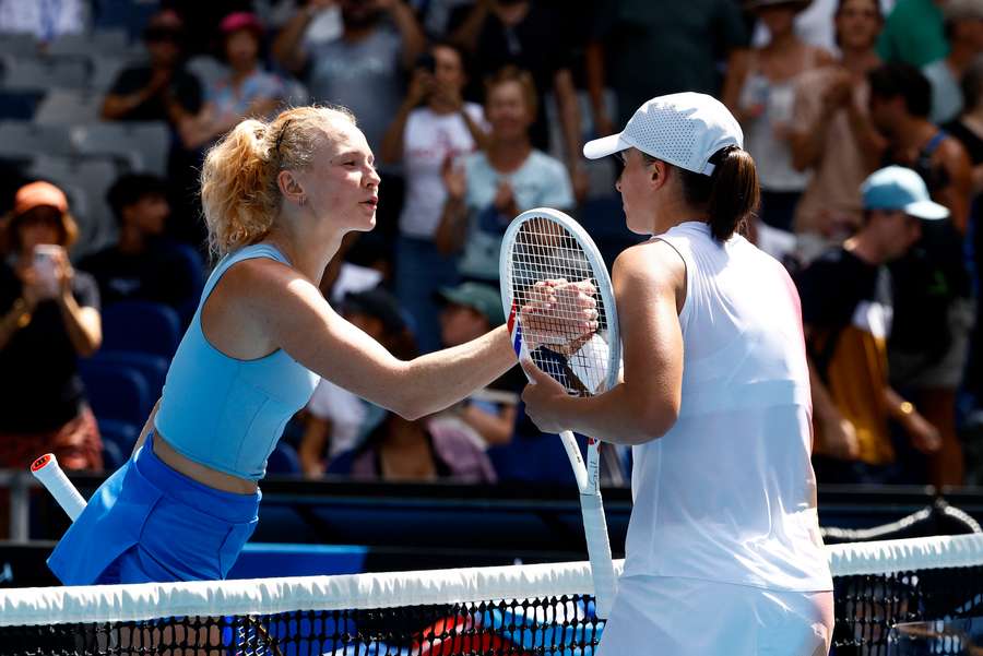 Iga Swiatek shakes hands with Czech Republic's Katerina Siniakova after winning her first-round match