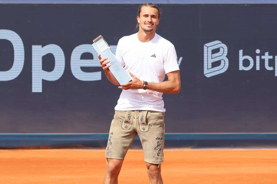 Alexander Zverev in Lederhose und mit seinem BMW Open Titel bestückt.