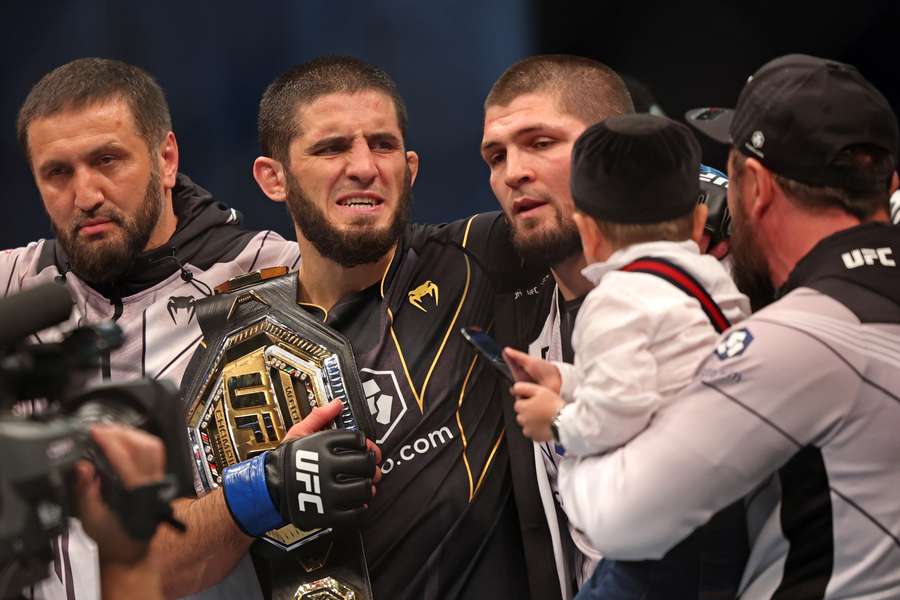 Islam Makhachev (2nd-L) celebrates with his team including Khabib Nurmagomedov after defeating Charles Oliveira for the UFC lightweight championship