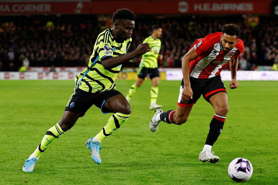 Arsenal's Bukayo Saka (L) in action against Sheffield United