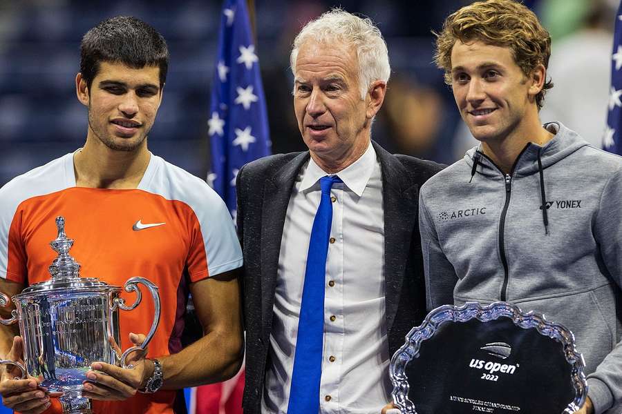 John McEnroe, încadrat de Alcaraz (stânga) și Ruud după finala US Open din 2022
