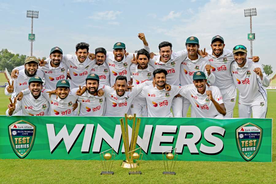 Bangladesh's players pose with the trophy as they celebrate after winning the second and last Test against Pakistan