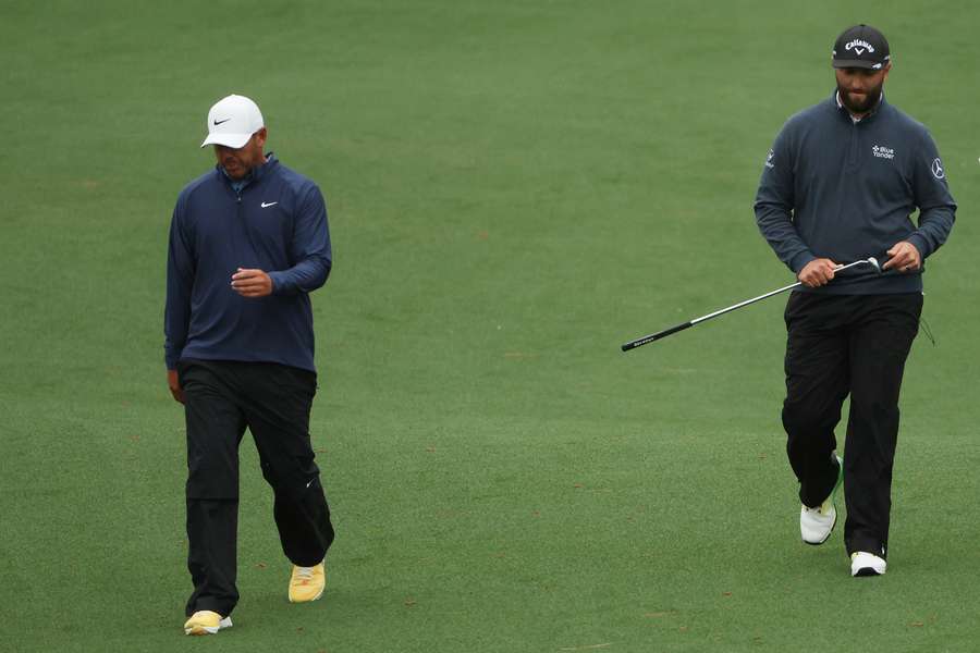 Brooks Koepka of the United States and Jon Rahm of Spain walk up the second fairway