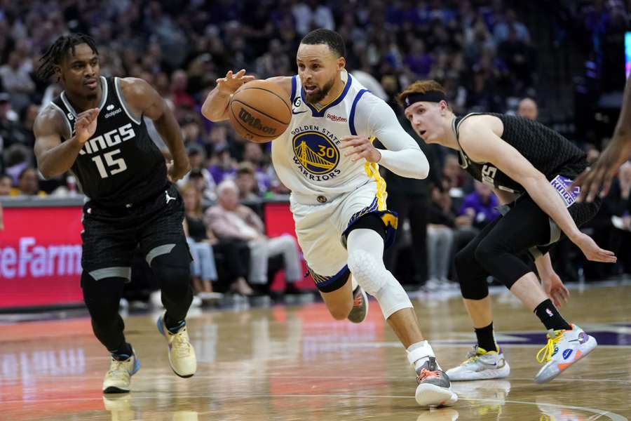 Stephen Curry (midden) in duel met Kings-spelers