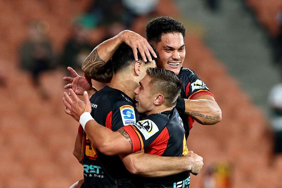 Shaun Stevenson of the Chiefs is congratulated on scoring a try by Cortez Ratima and Quinn Tupaea