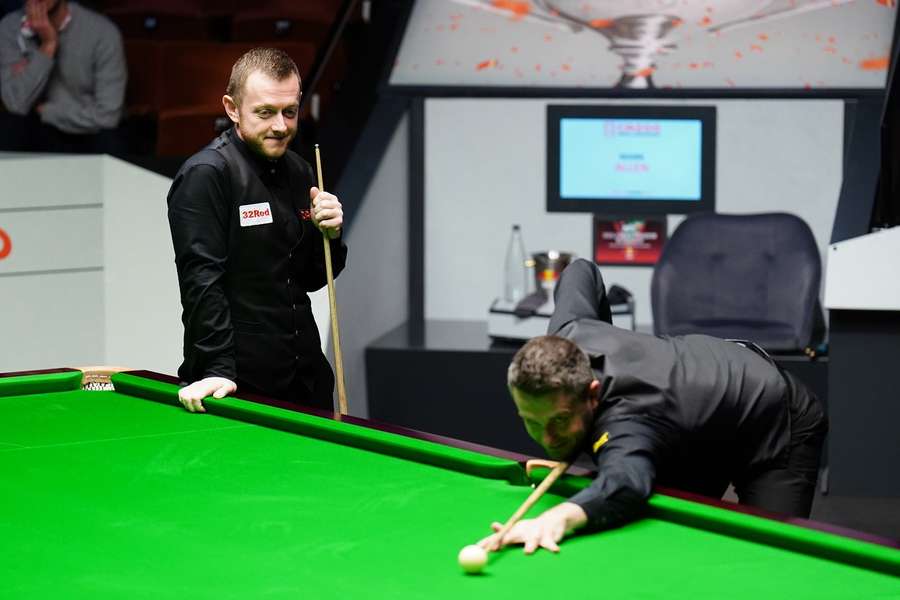 Mark Allen kijkt van dichtbij toe hoe Mark Selby de laatste bal van de tweede sessie pot: 7-6