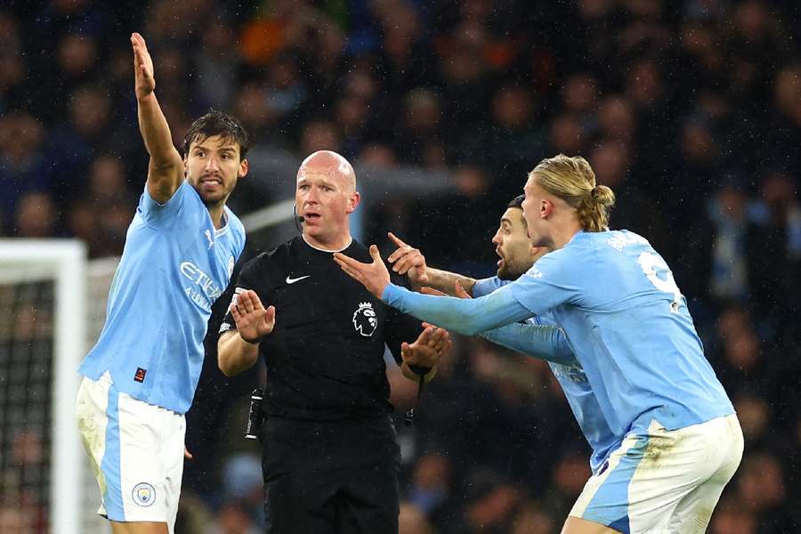 Players surround the referee during City's 3-3 draw with Spurs