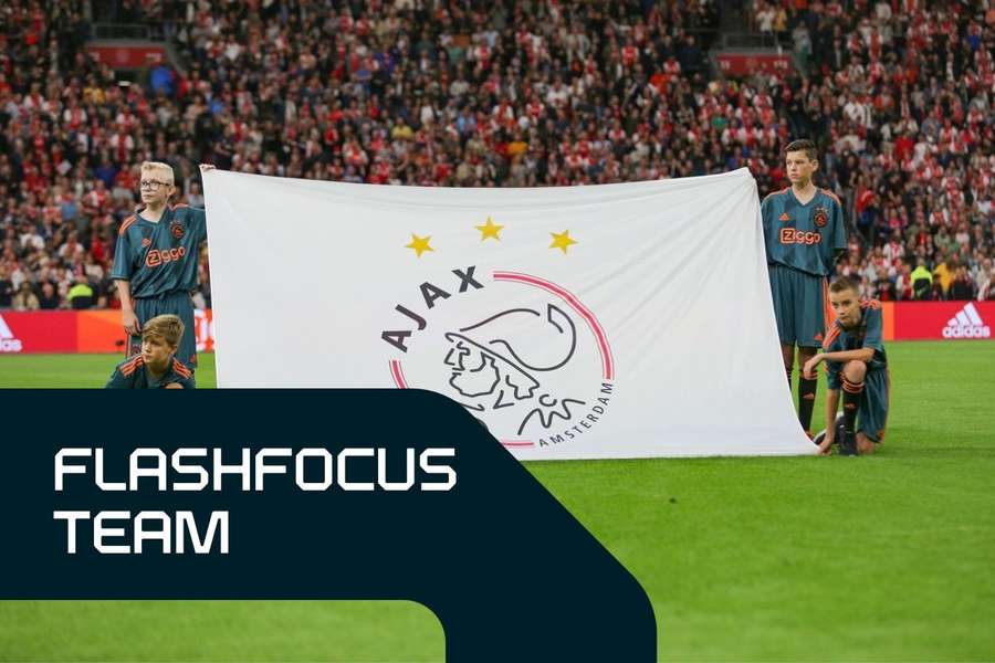 Young fans hold Ajax's logo before a match