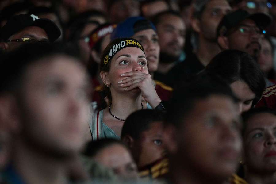 Una aficionada observa los hechos con preocupación.