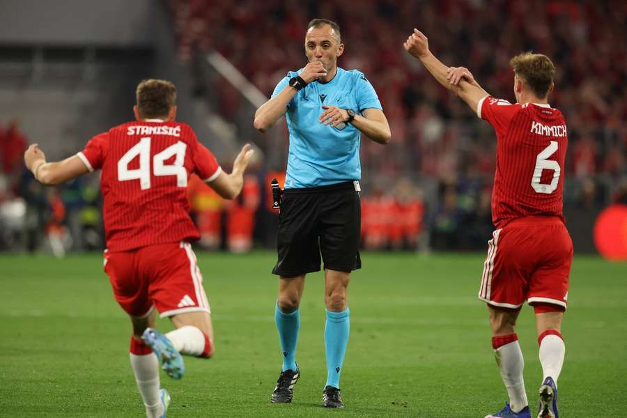Referee Joao Pinheiro communicating with Bayern players.