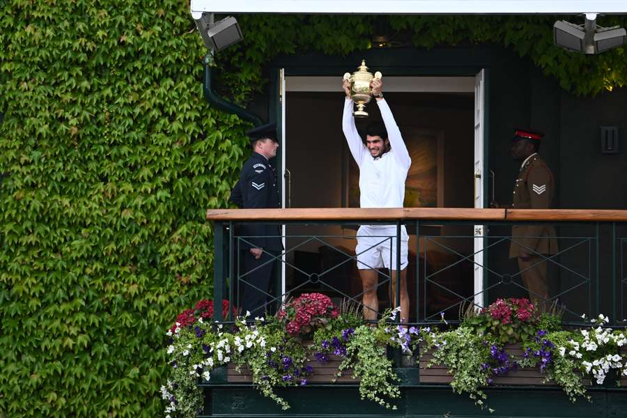 Alcaraz saluda desde el balcón del All England Tennis Club con el trofeo de campeón