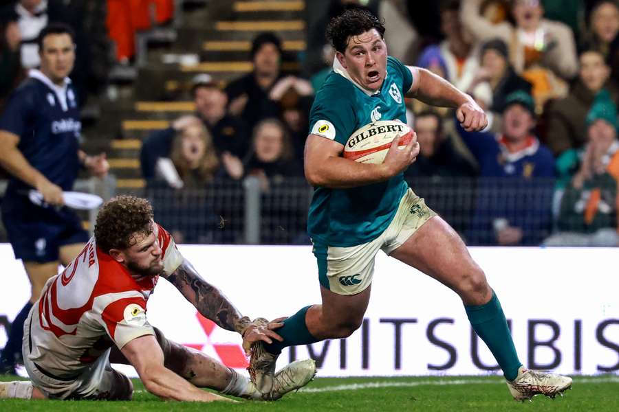 Ireland's Tom Stewart (R) breaks past Japan's Warner Dearns (L) to score a try.
