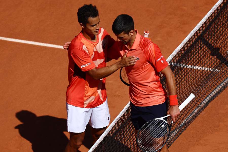 Novak Djokovic is congratulated by Juan Pablo Varillas after their last 16 tie