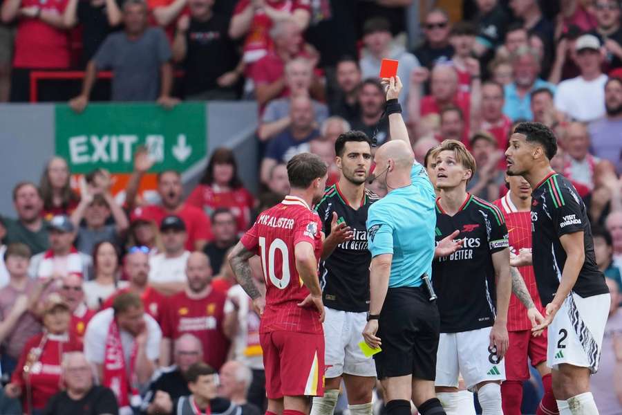 Referee Anthony Taylor shows a red card to Arsenal's Mikel Merino, during the game against Liverpool on Sunday, May 11, 2025.