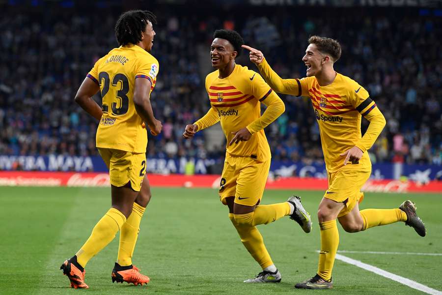 Barcelona defender Jules Kounde (L) celebrates scoring his team's fourth goal with defender Alejandro Balde (C) and midfielder Gavi