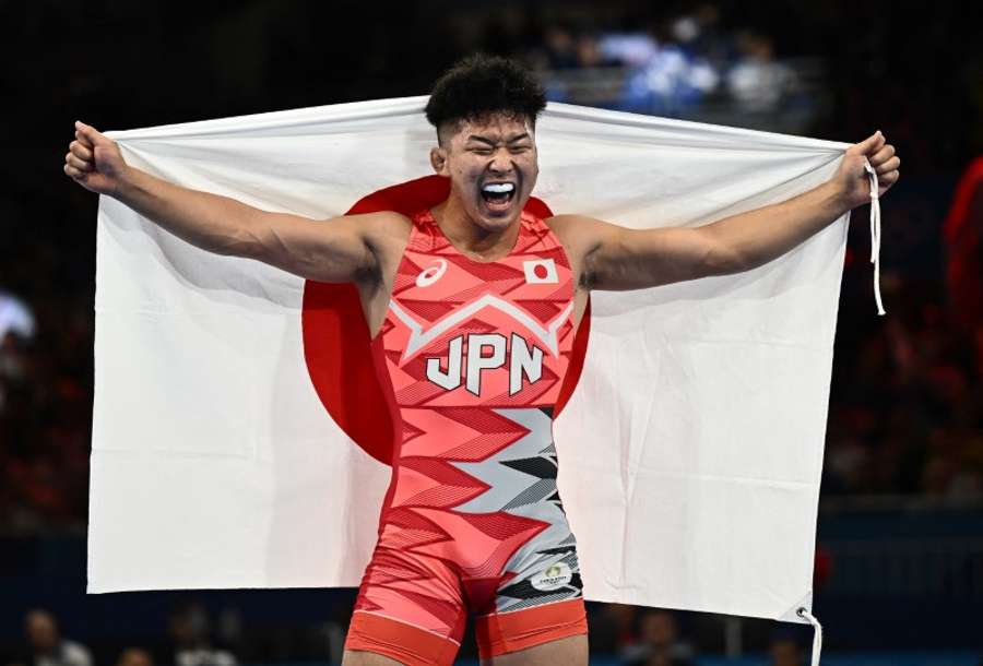 Nao Kusaka of Japan celebrates winning gold in the match against Demeu Zhadrayev of Kazakhstan