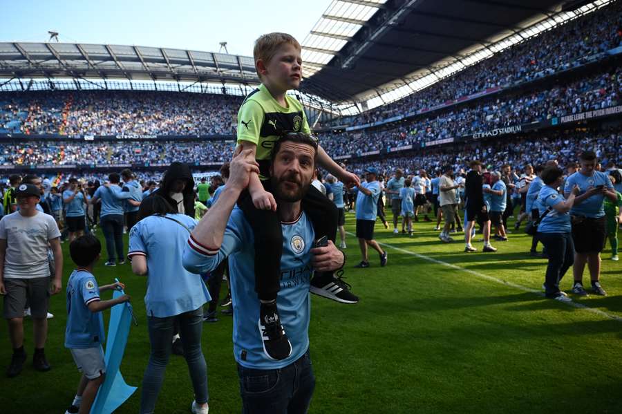 Manchester City fans invade the pitch as they celebrate winning the title