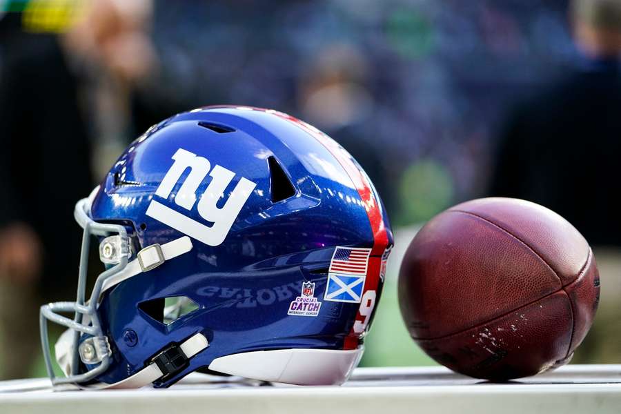 A New York Giants helmet sits beside a football at Tottenham Hotspur Stadium in London, England (2023)