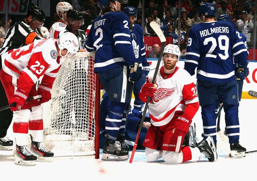 Goaltender Stolarz's bare hand behind Detroit forward Compher pulled the puck out of the crease