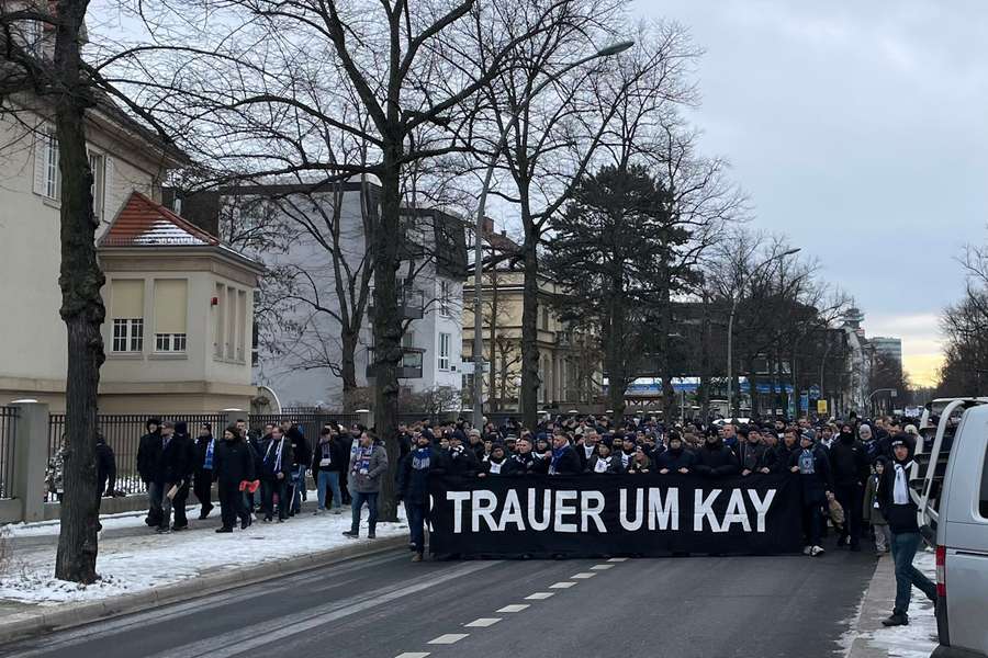 Os adeptos do Hertha marcham para o estádio com uma faixa negra