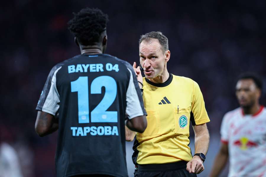 El árbitro alemán Bastian Dankert, hablando con Edmond Tapsoba, del Leverkusen. 