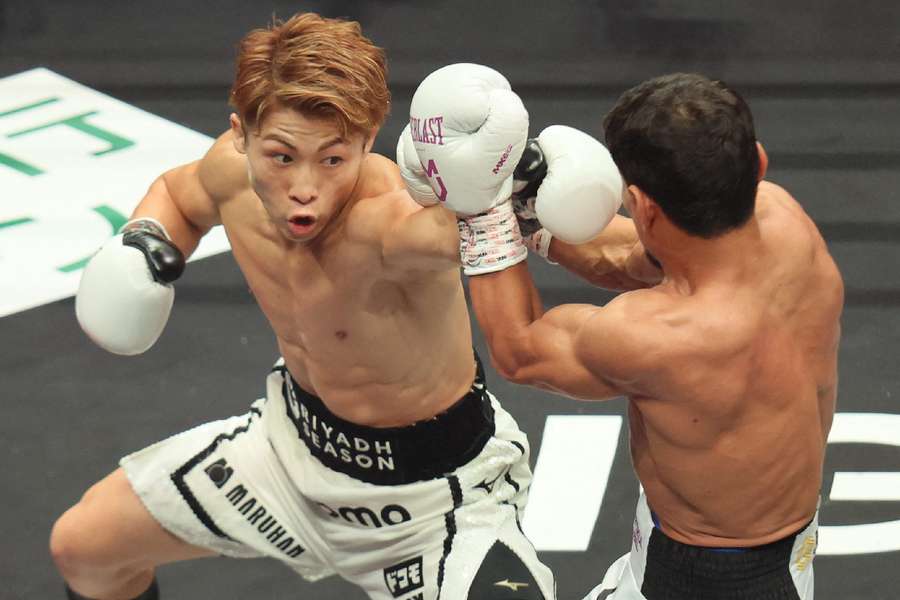 Japan's Naoya Inoue (L) fights against Uzbekistan's Murodjon Akhmadaliev during their super bantamweight boxing title fight