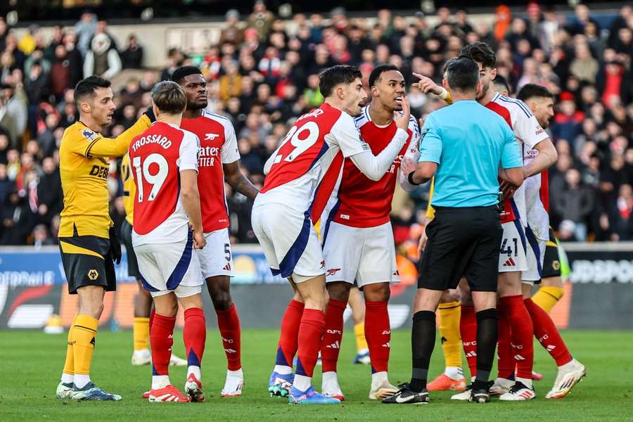 Arsenal's players surround referee Michael Oliver after the red card for Myles Lewis-Skelly