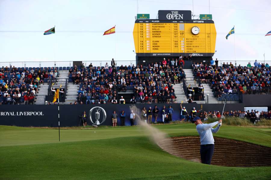 Rory McIlroy attempts to play out of a bunker on the 18th hole during the first round