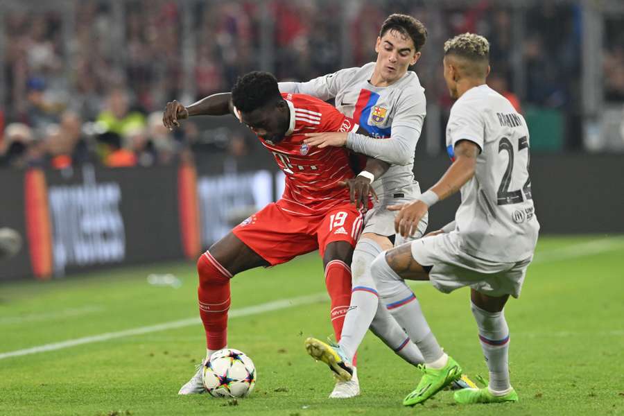 Barcelona midfielder Gavi (C) tackles Alphonso Davies of Bayern Munich.