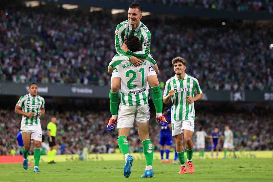 Marc Roca y Giovani Lo Celso celebran un gol.