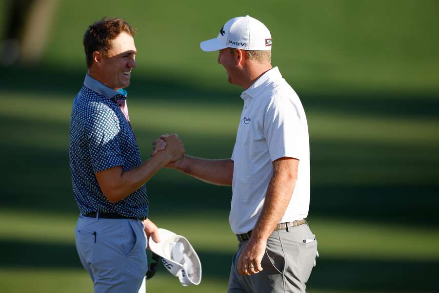 Justin Thomas (L) of the United States congratulates Tom Hoge (R) of the United States on the ninth green after his course record 62