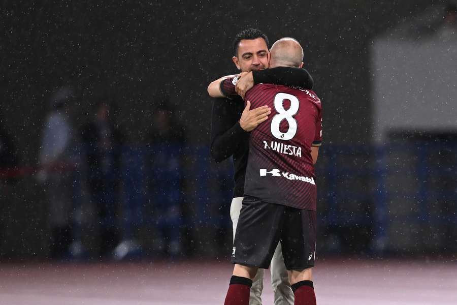 Barcelona coach Xavi hugs Vissel Kobe's Andres Iniesta