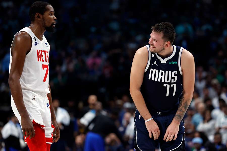 Luka Doncic sonríe a Kevin Durant durante un Nets-Mavericks.