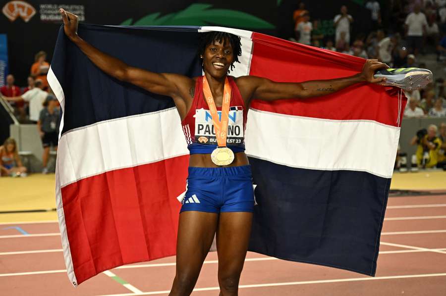 Paulino celebrates with a flag after winning gold
