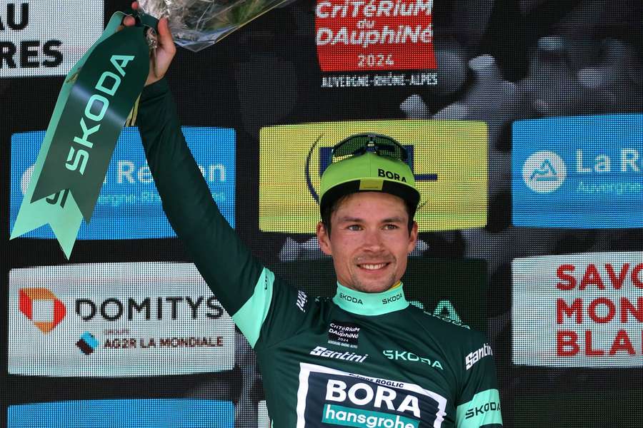 Primoz Roglic celebrates wearing the sprinter's green jersey on the podium