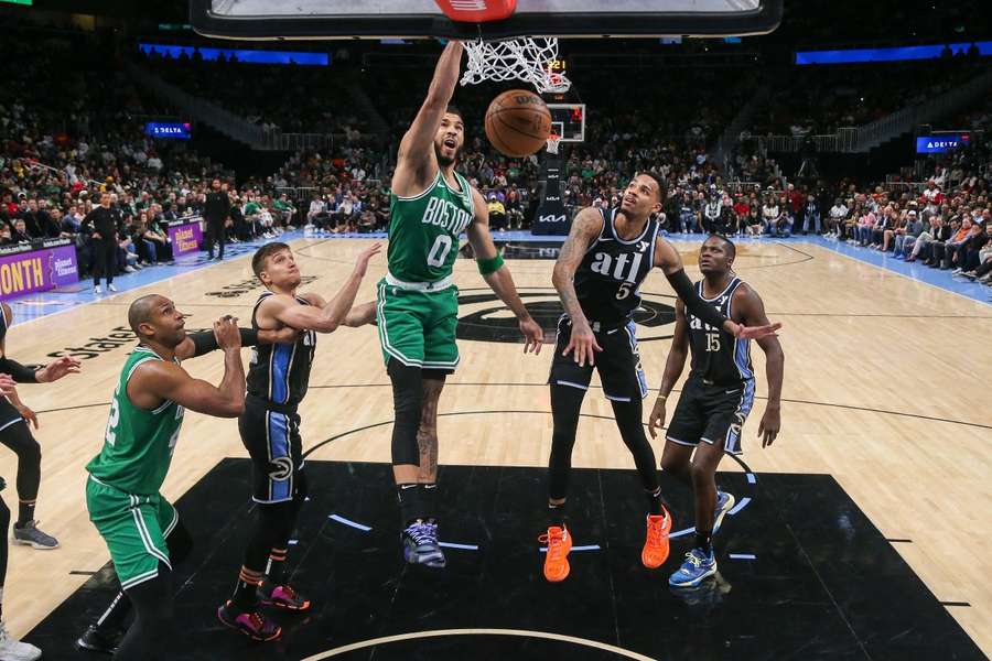 Boston Celtics forward Jayson Tatum dunks past Atlanta Hawks guard Dejounte Murray in the second half