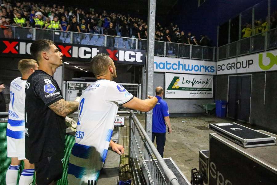 Spelers van PEC Zwolle proberen de hooligans tot bedaren te brengen