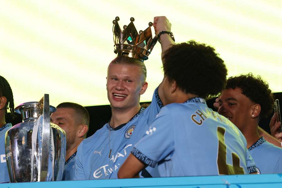 Atacantul norvegian al lui Manchester City #09 Erling Haaland zâmbește în timpul unei parade a victoriei cu autobuzul descoperit