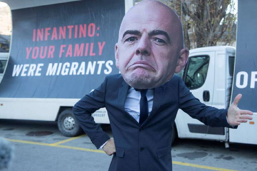 An activist wears a portrait of FIFA President Gianni Infantino during the protests 