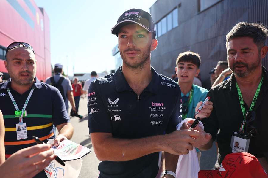 Alpine's Pierre Gasly signs autographs for fans as he arrives ahead of practice in Monza
