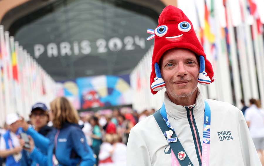 Volunteer is captured with the Olympic mascot hat during the torch relay