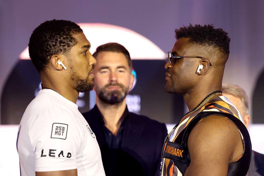 Anthony Joshua (L) and Francis Ngannou (R) face off at the press conference ahead of their 'Knockout Chaos' heavyweight fight in Riyadh, Saudi Arabia