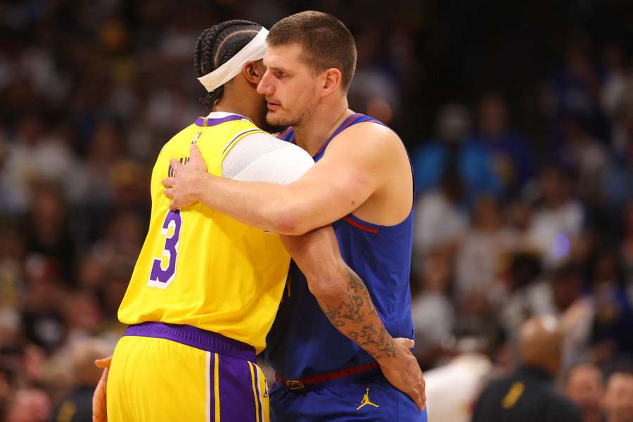 Sârbul Nikola Jokic (drepta) și Anthony Davis (LA Lakers) după partida inaugurală a sezonului din NBA