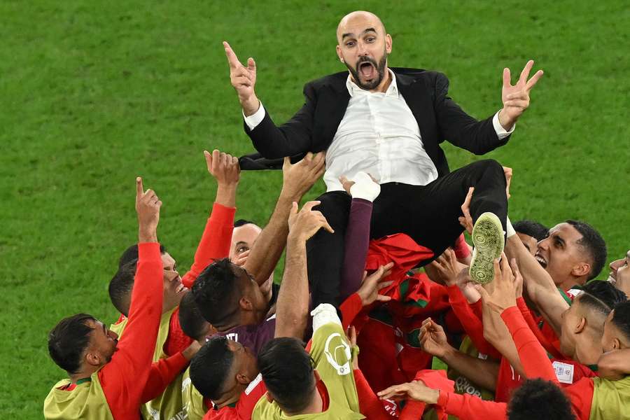 Walid Regragui celebrates with his players after their win over Spain.